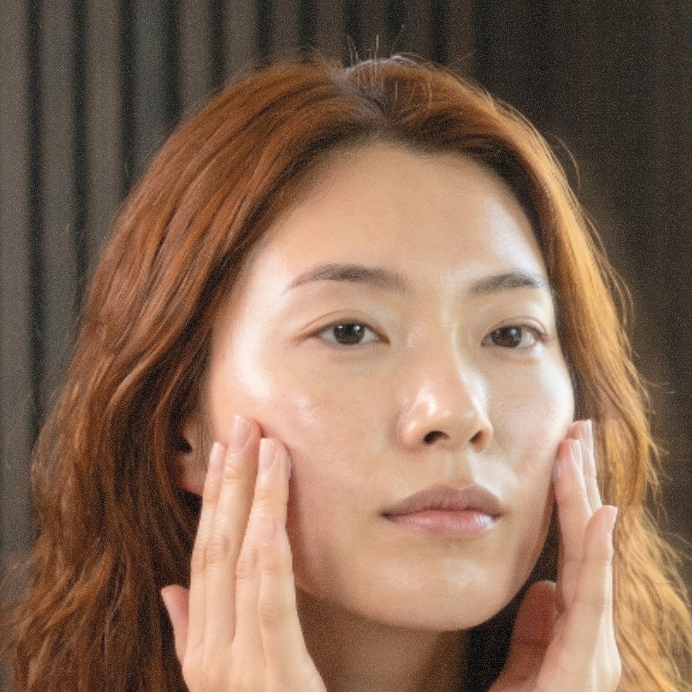 Spreading the cream evenly across the face with the fingertips.