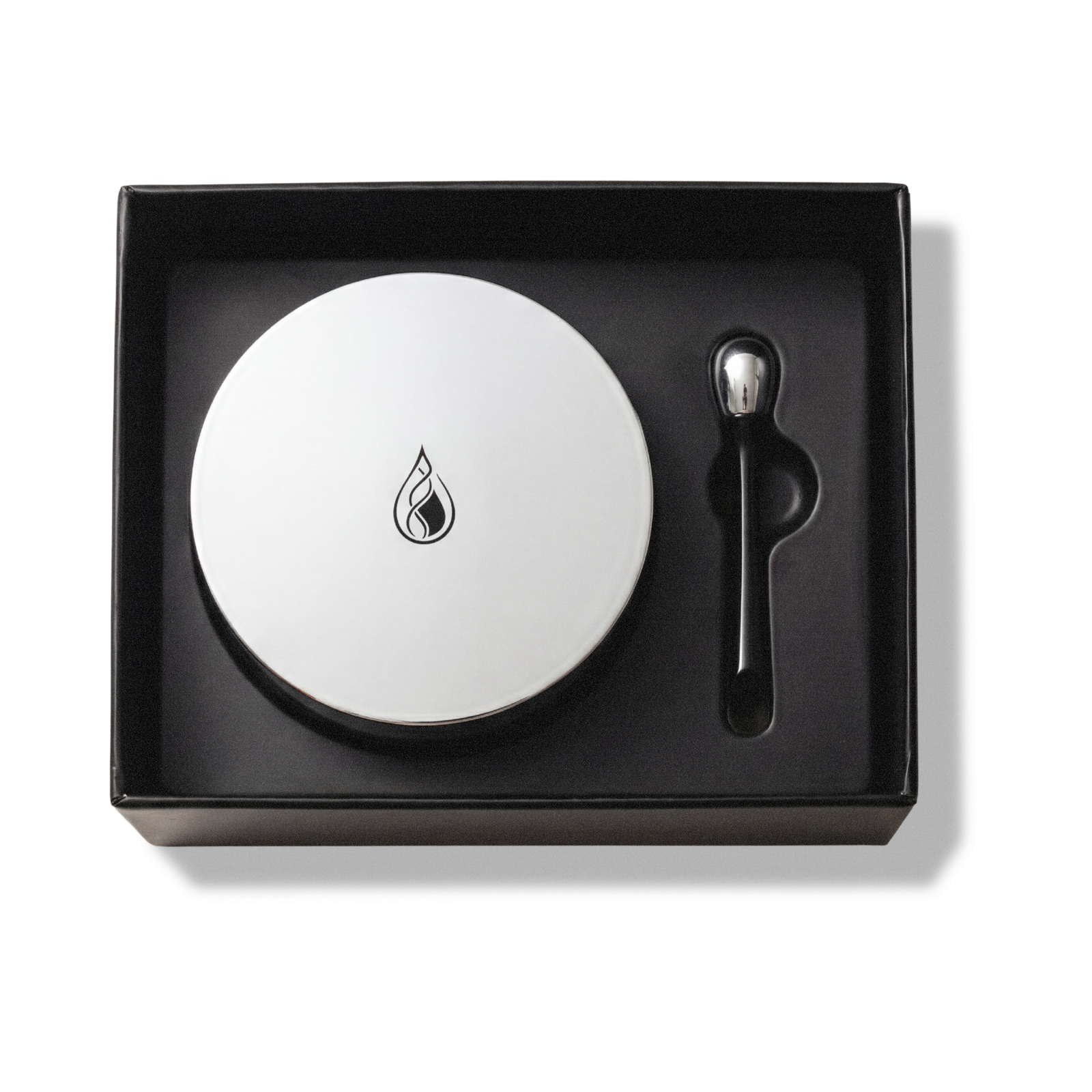 Crème Régénérante presentation box with silver-lidded jar and weighted black spoon.